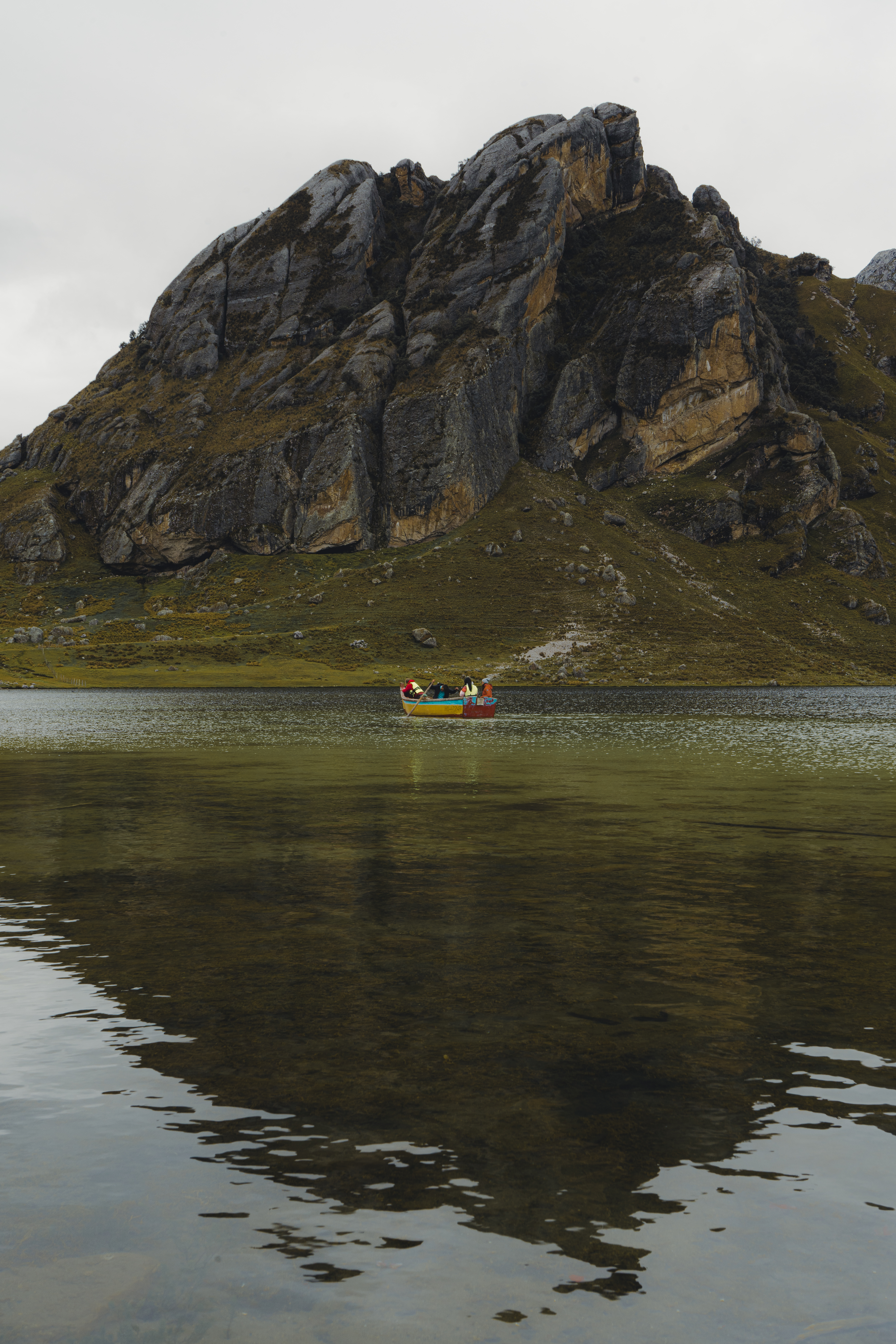 Bote en la laguna con reflejo del cerro en el agua